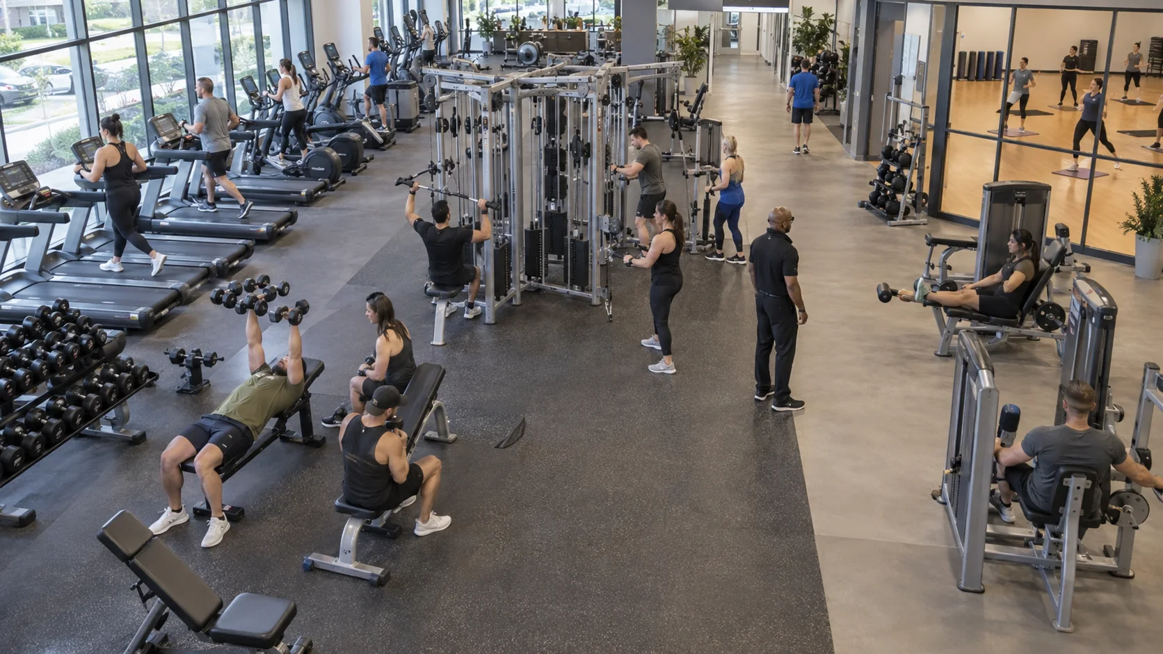 Commercial fitness club with members using equipment across several activity zones