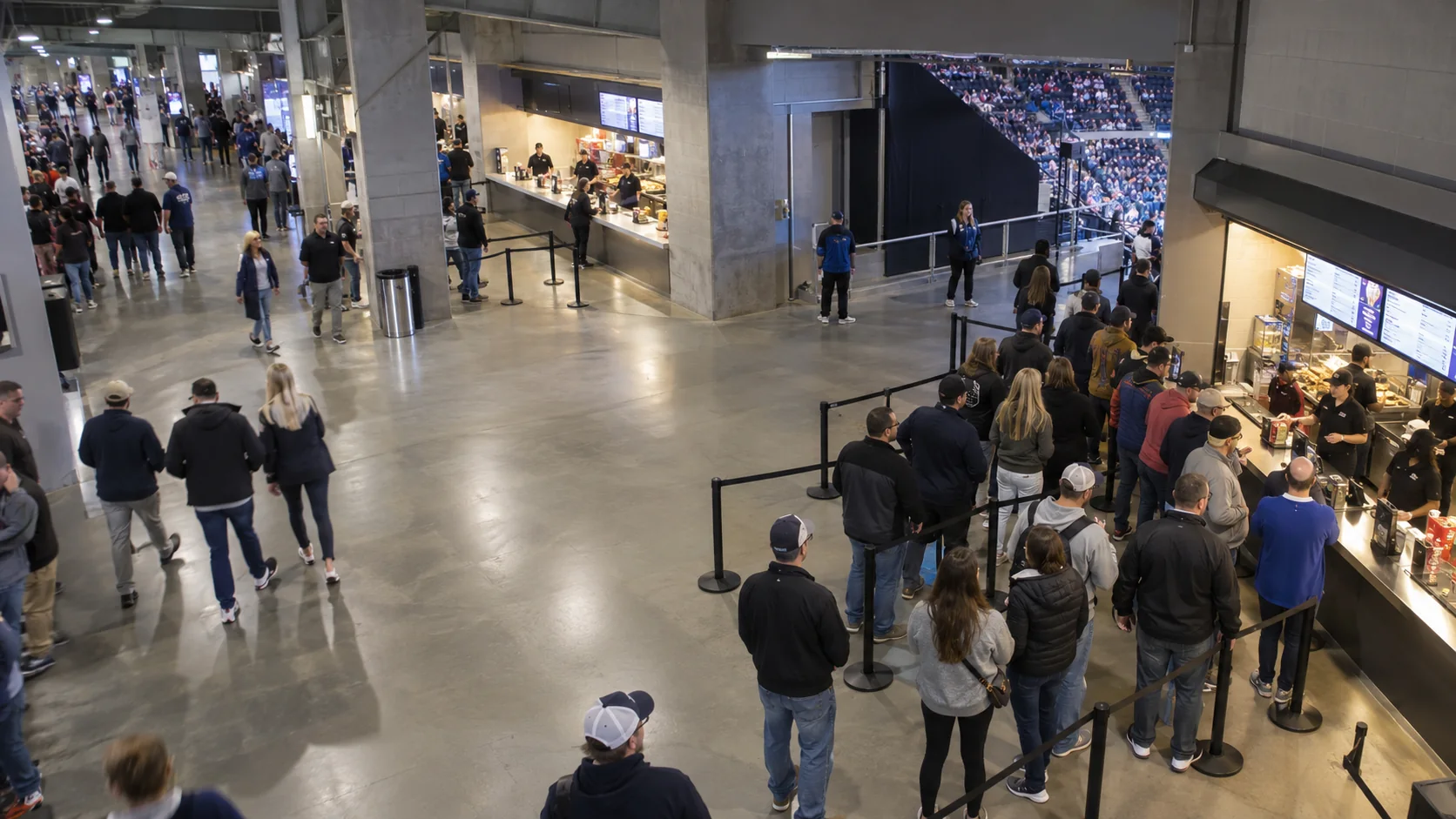 American sports arena concourse with an orderly concession queue and nearby available capacity